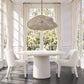 white rattan pendant hanging over a white round dining table