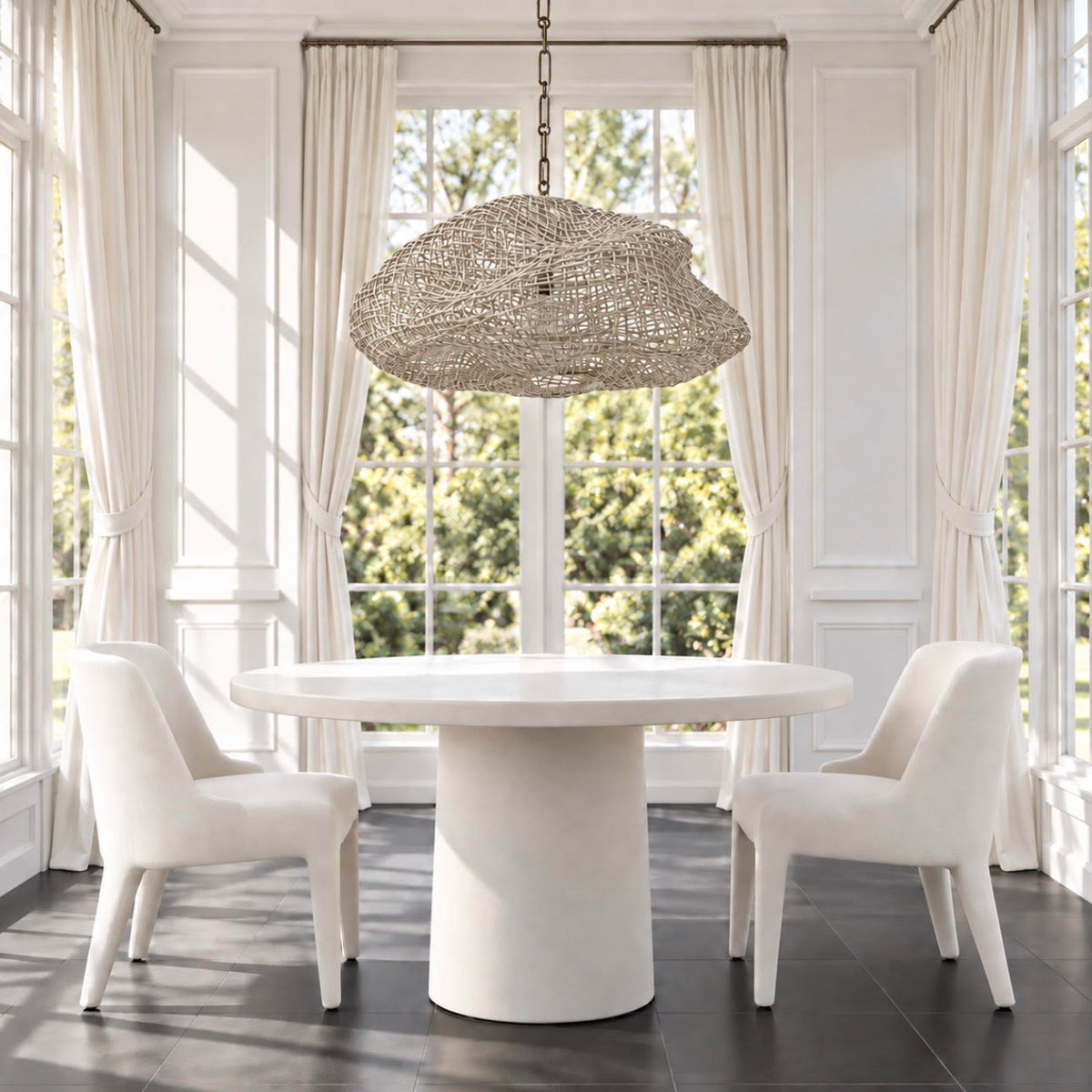 white rattan pendant hanging over a white round dining table