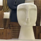 Decorative head sculptures with candles on a shelf