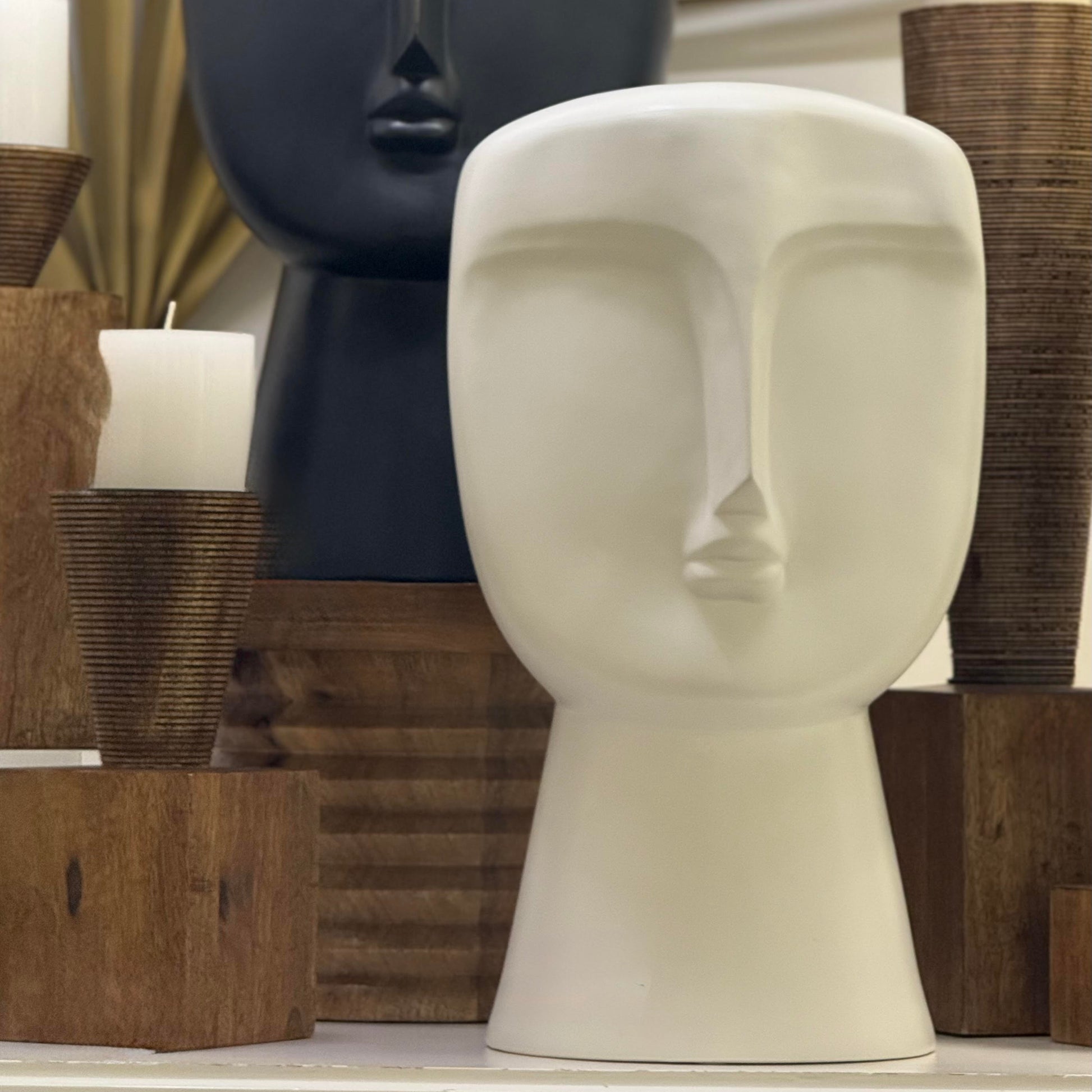 Decorative head sculptures with candles on a shelf