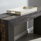 Modern console table with a tray on top against a neutral wall.