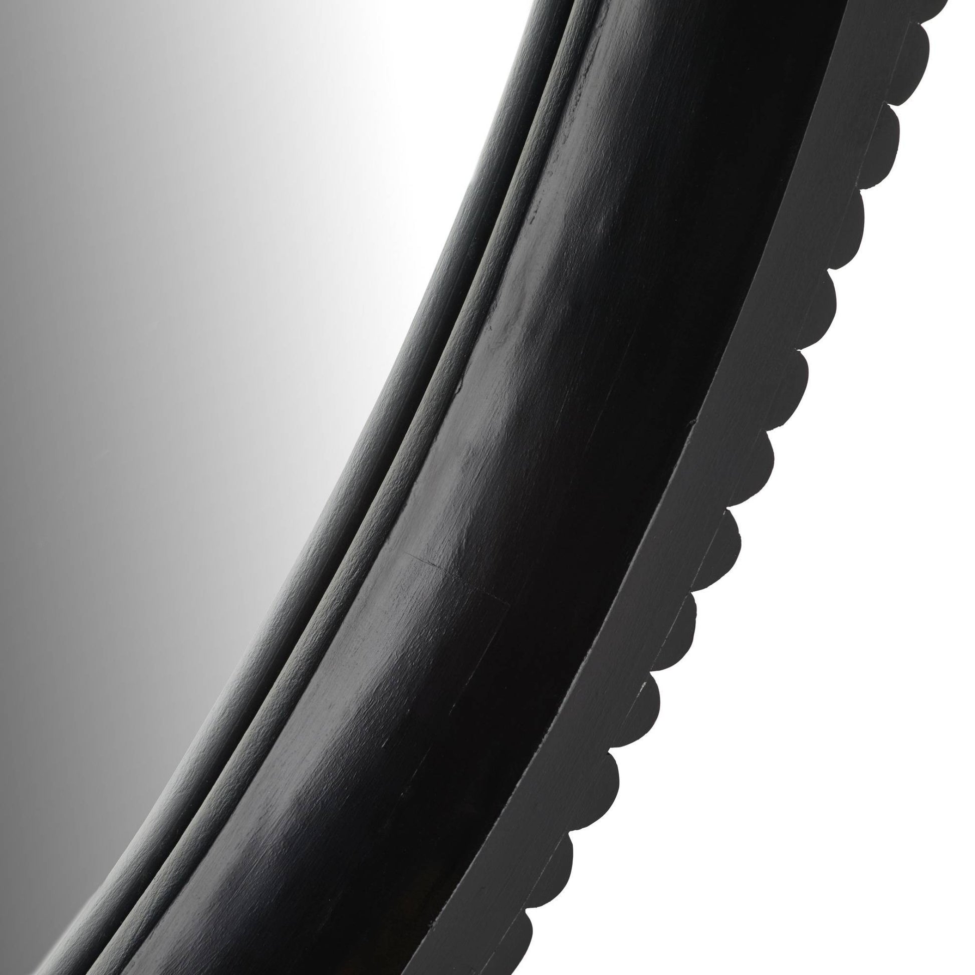 Close-up of a black circular object with a reflective surface on a white background