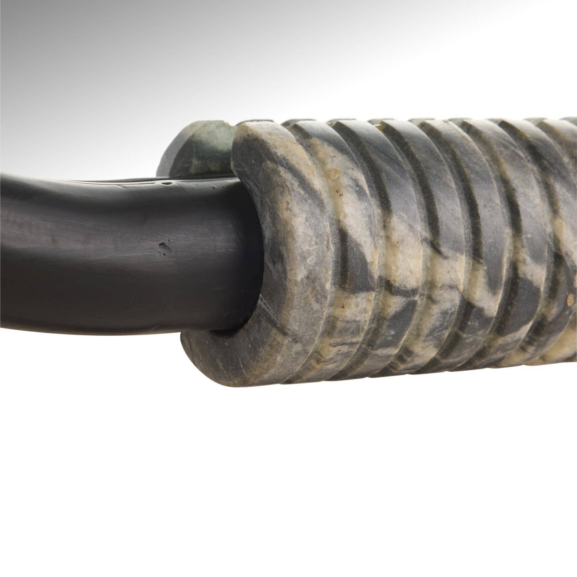 Close-up of a textured metal cable on a white background