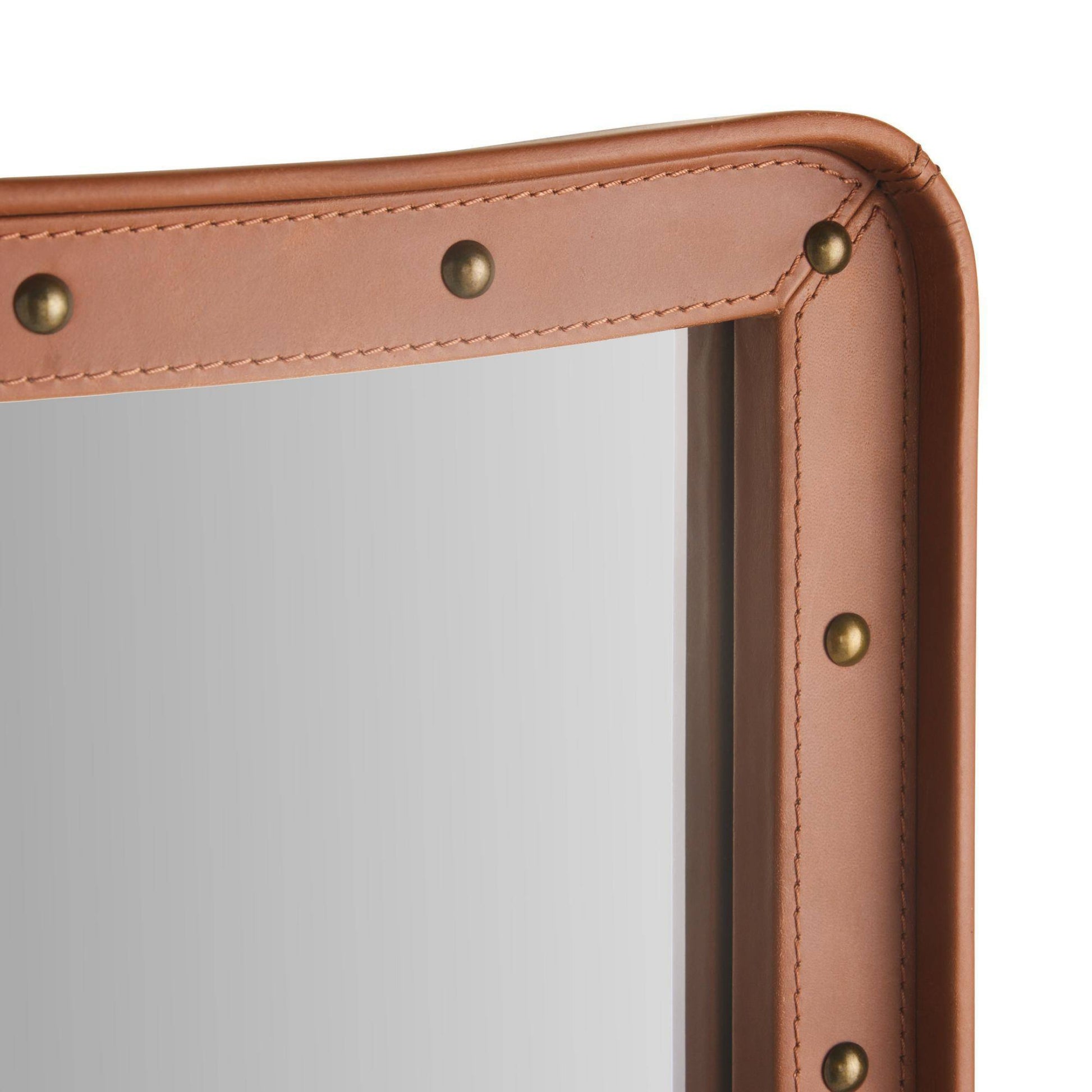 Close-up of a brown leather product with gold rivets on a white background