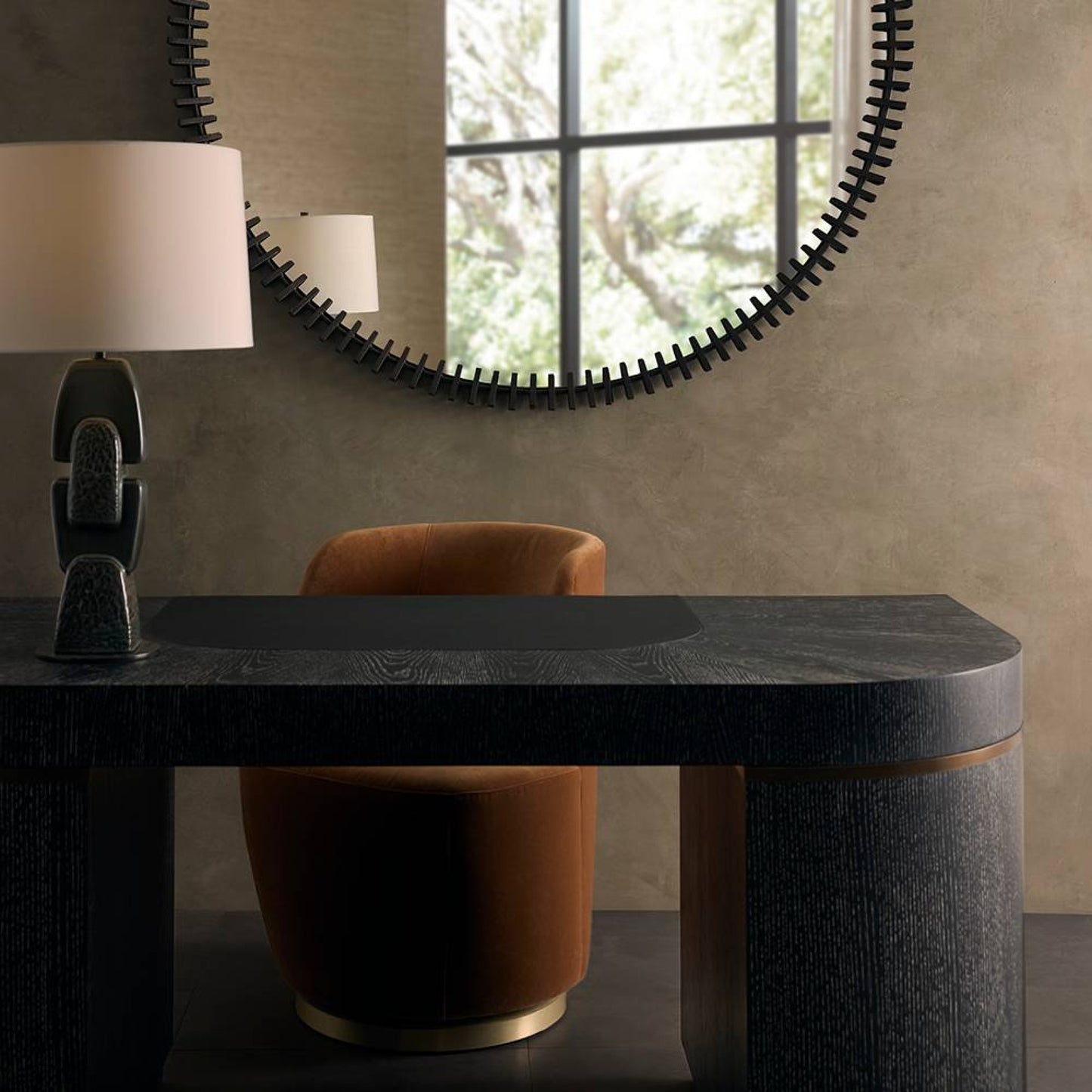 Modern interior with a black marble console table, round mirror, and orange chair.