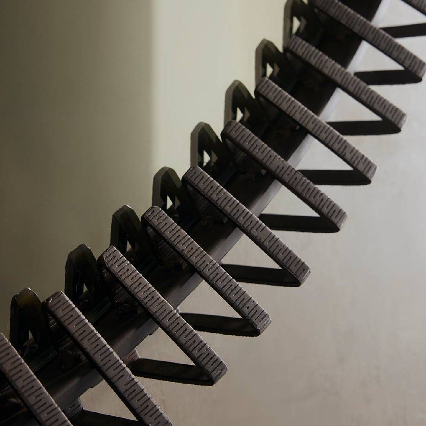 Close-up of a black metal ladder against a plain background