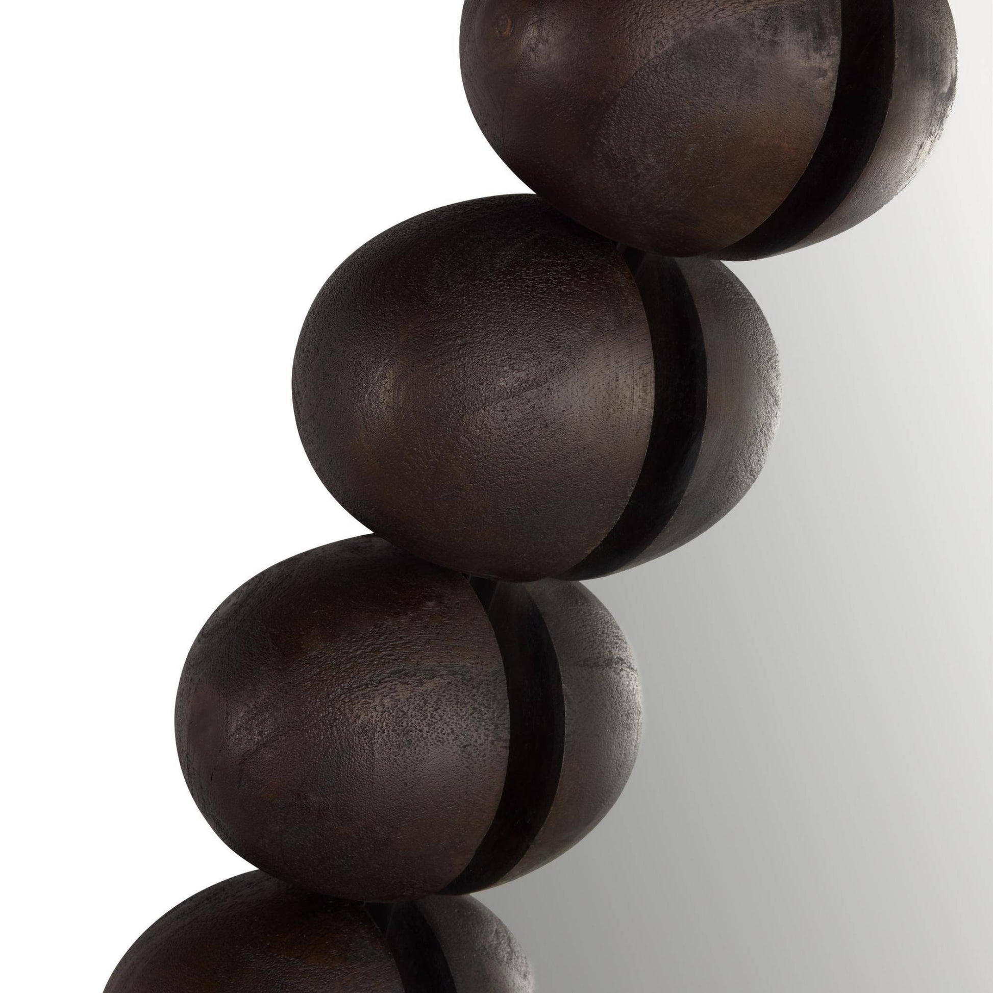 Close-up of dark brown wooden beads on a white background