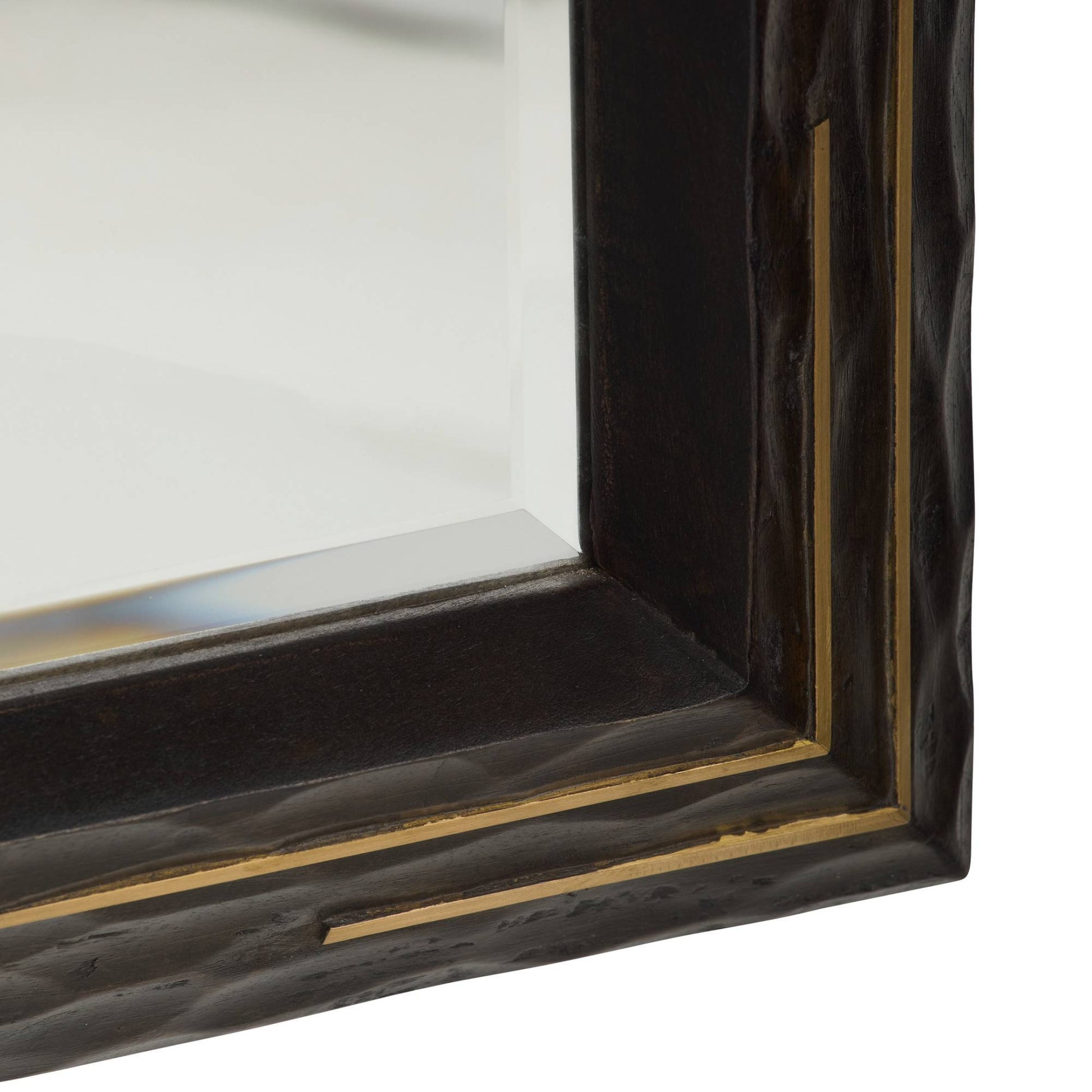 Close-up of a rectangular mirror with a dark wood frame and gold accents.