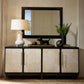 Decorative console table with a lamp, mirror, and decorative items in a room setting.