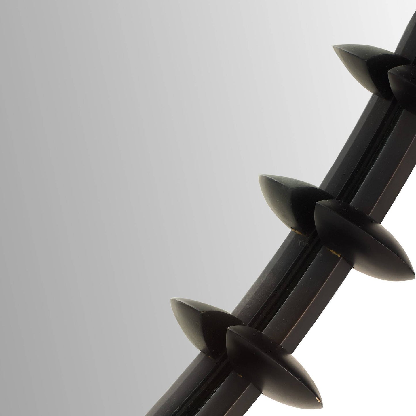 Close-up of a black metal barbed wire on a light gray background