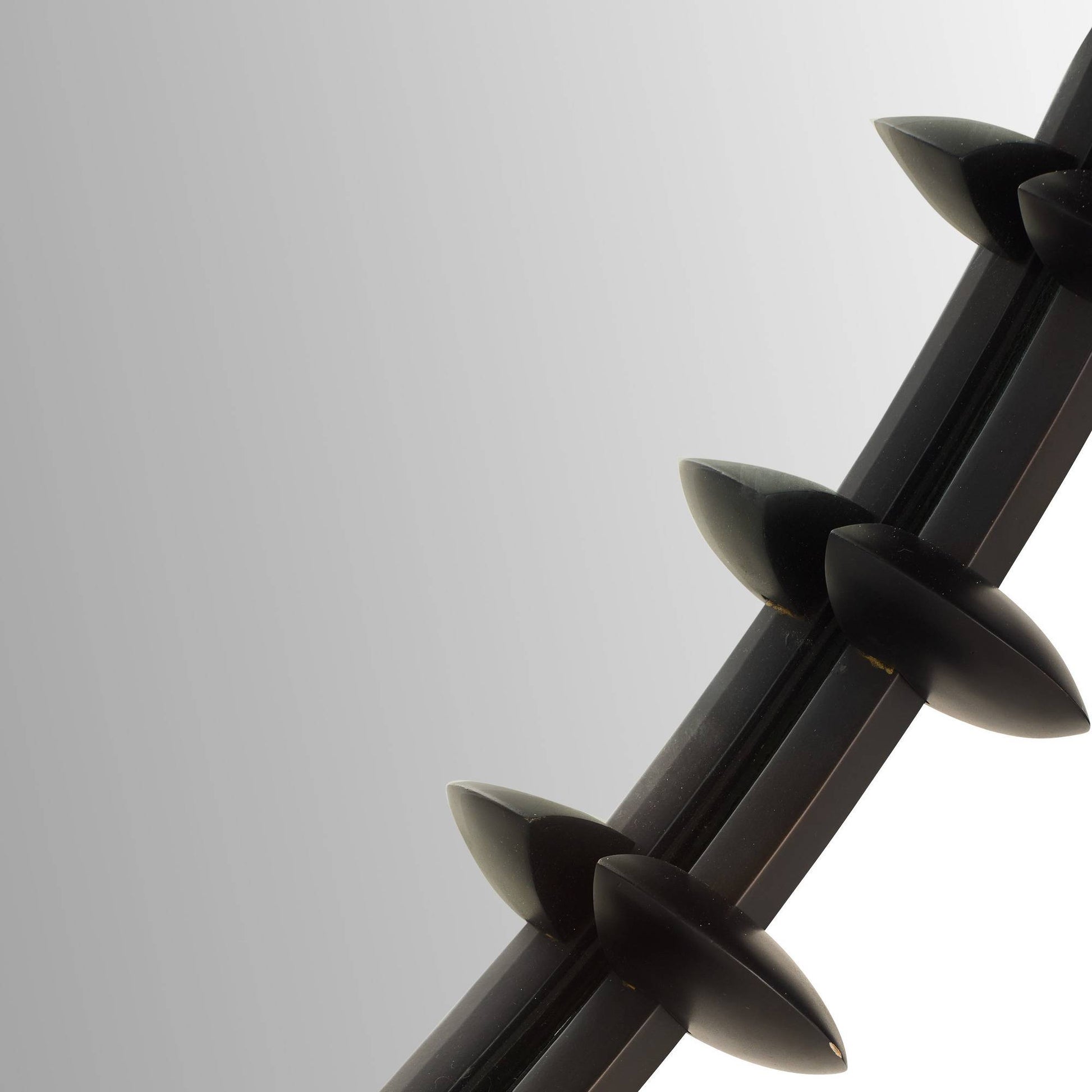 Close-up of a black metal barbed wire on a light gray background