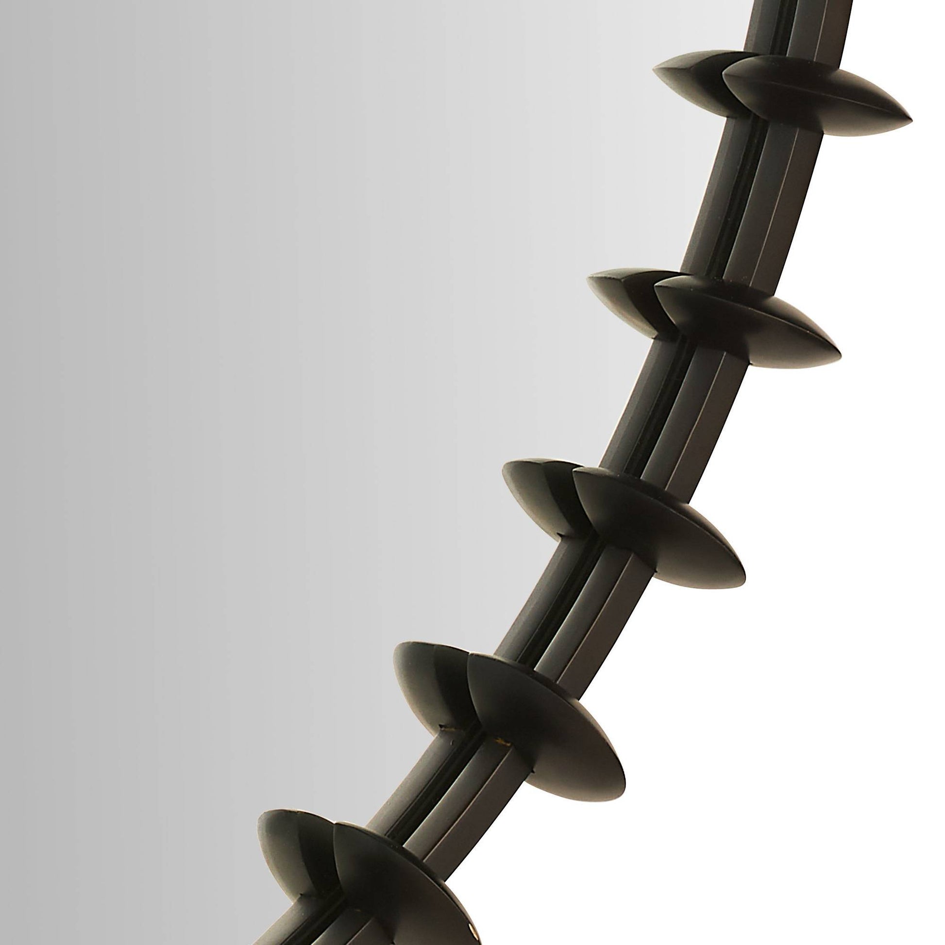 Close-up of a coiled black metal rod on a white background