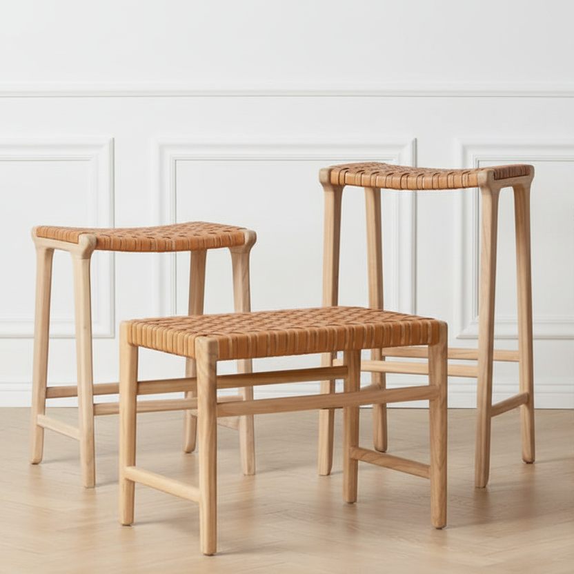 Four wooden stools with woven seats against a white paneled wall.