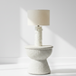 White textured table lamp with a beige lampshade on a white background