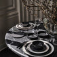 Dining table setting with black and white dishes on a marble table.