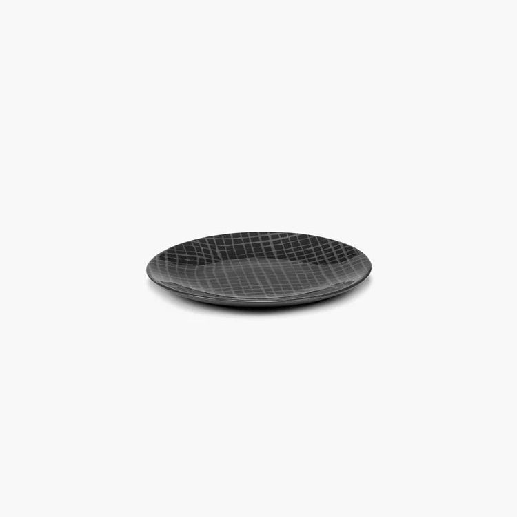 Black ceramic plate with textured pattern on a white background