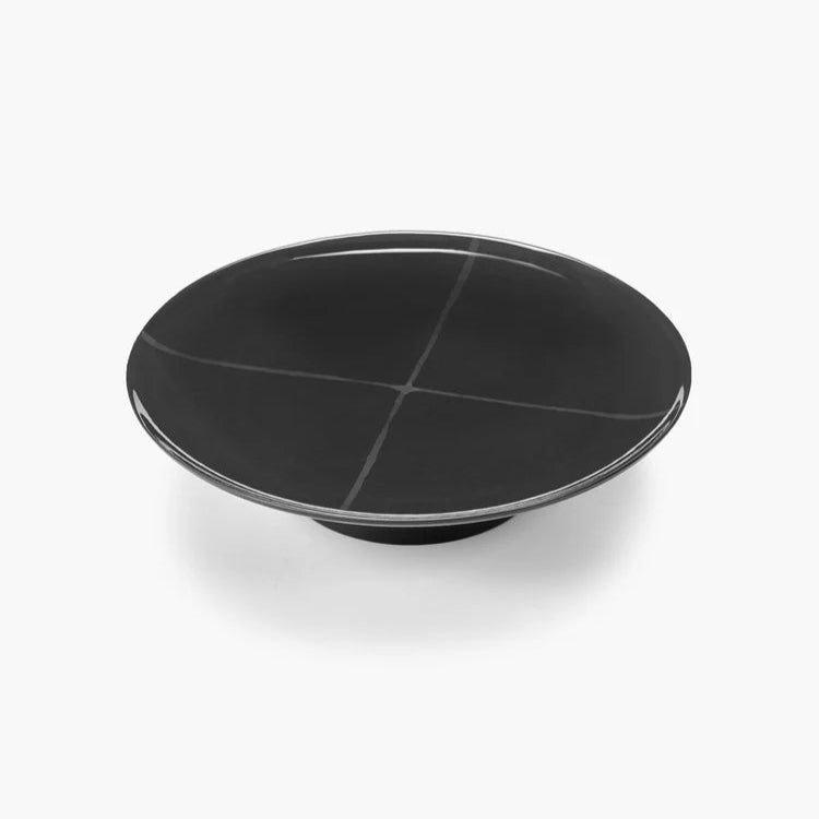 Black ceramic plate with a glossy finish on a white background