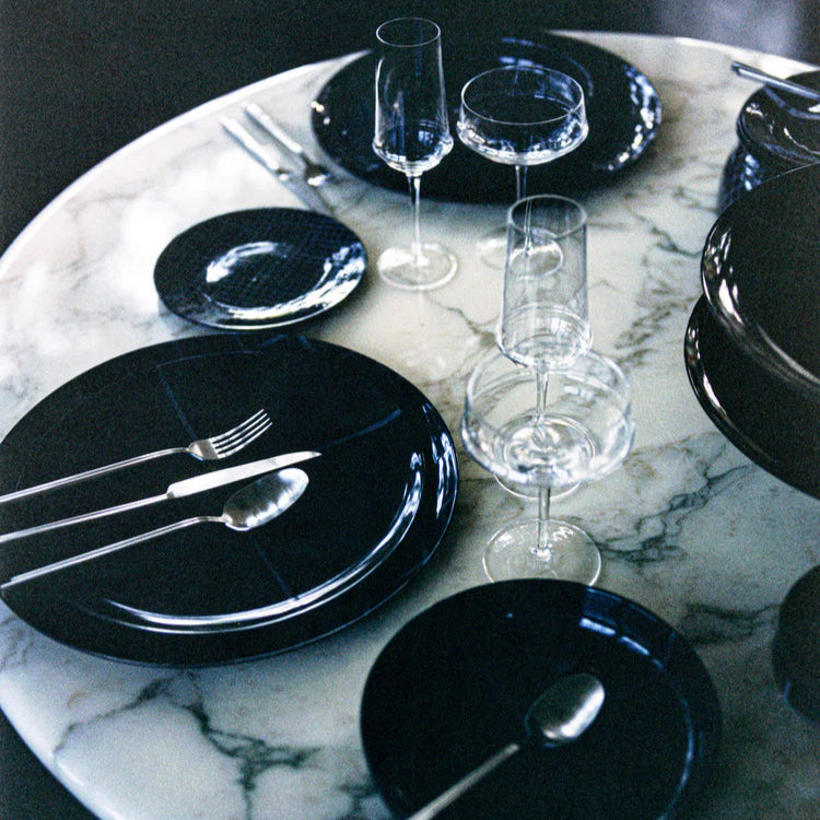 Black plates and glasses on a marble table