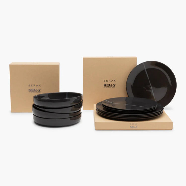 Set of black ceramic plates and bowls with Kraft paper boxes on a white background