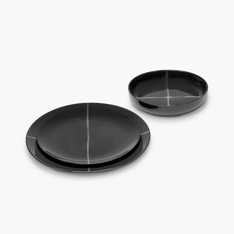 Two black ceramic plates on a white background