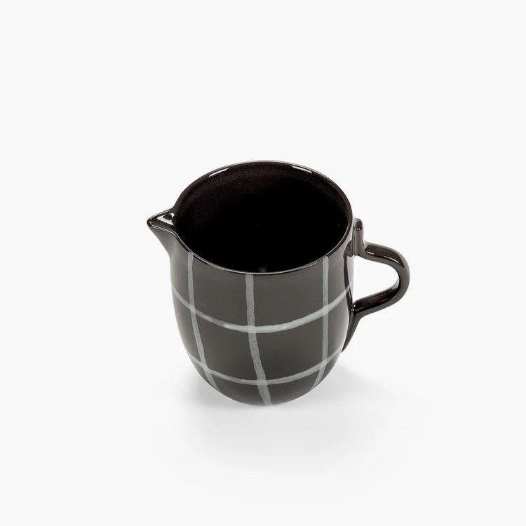 Black ceramic pitcher with grid pattern on a white background