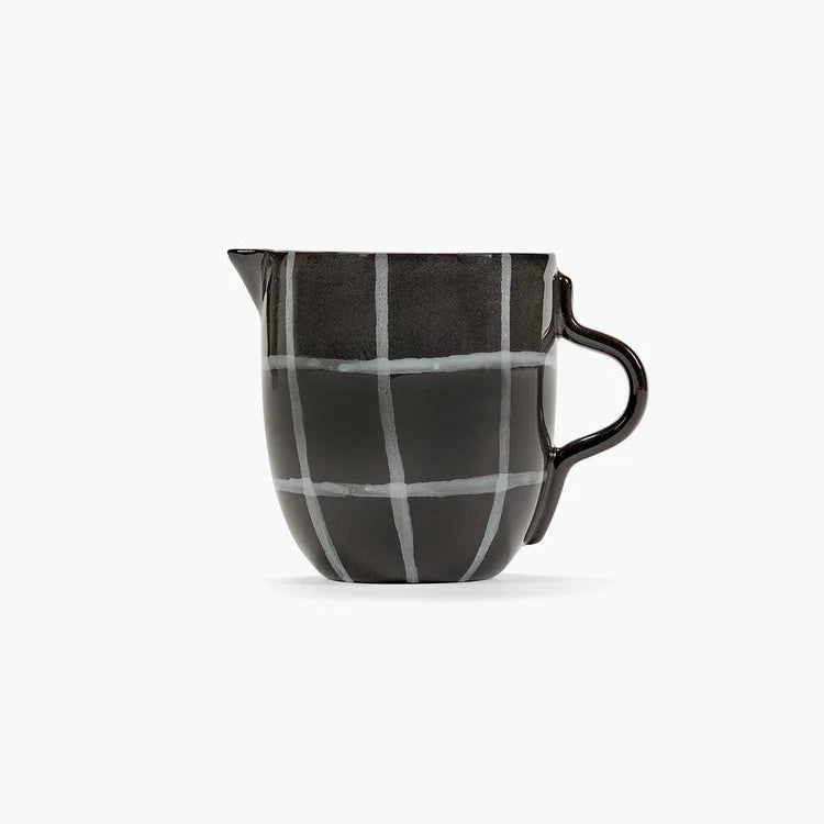 Black and white checkered ceramic pitcher on a white background