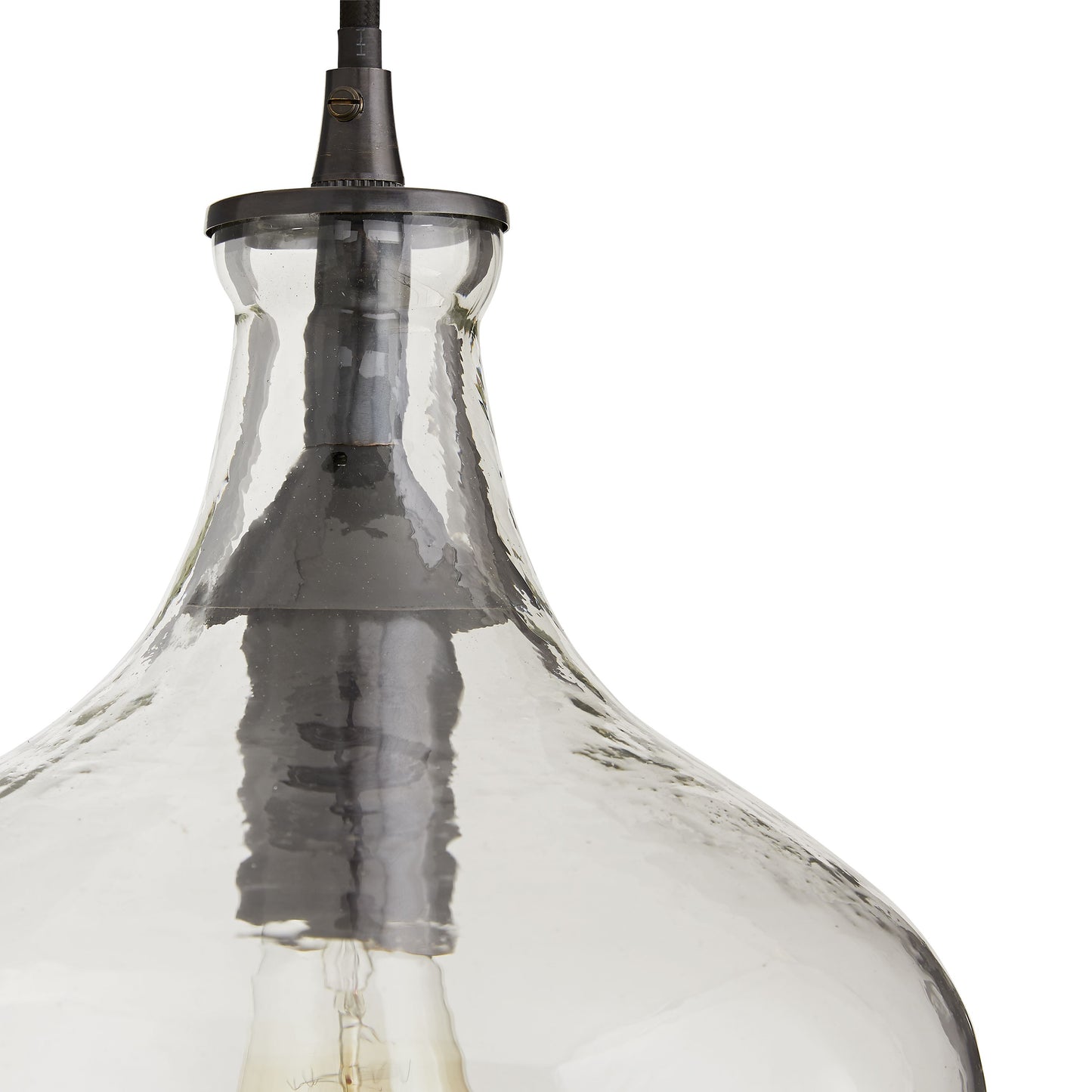 This one-light glass pendant has a black cloth cord and a simple round bronze canopy. The clear, hammered glass creates a warm glow when lit, making it a great powder room fixture. Shown with a Nostalgic thread bulb. Damp-rated, although limitedcovered outdoor conditions may affect finish. hardware